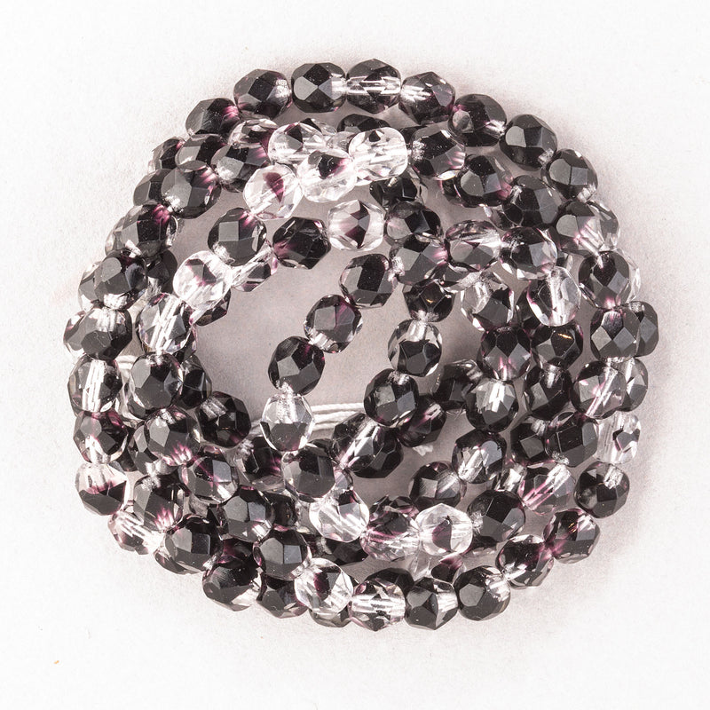 Czech firepolished faceted 6mm clear glass beads with dark amethyst  tortoise markings. 30"strand.