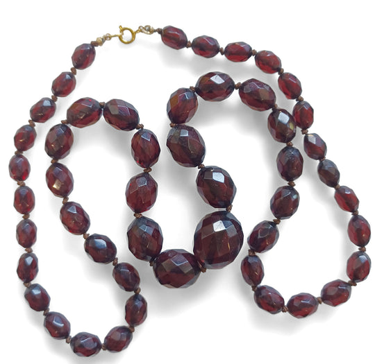 Art Deco 25" strand of knotted and graduated faceted oval cherry amber Bakelite beads. nlbk790