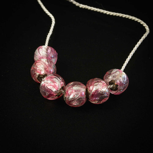 Murano foil beads, 1950s.  Clear glass with pink glass trailings over silver coil core