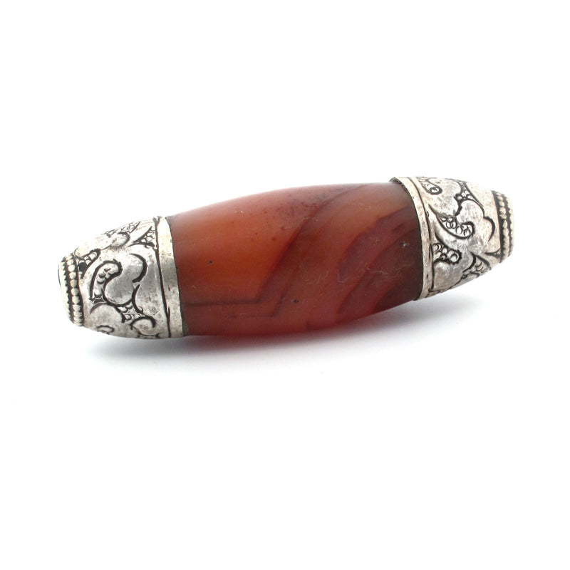 Nepali carved carnelian agate oval bead with repousse sterling silver caps. b4-car400