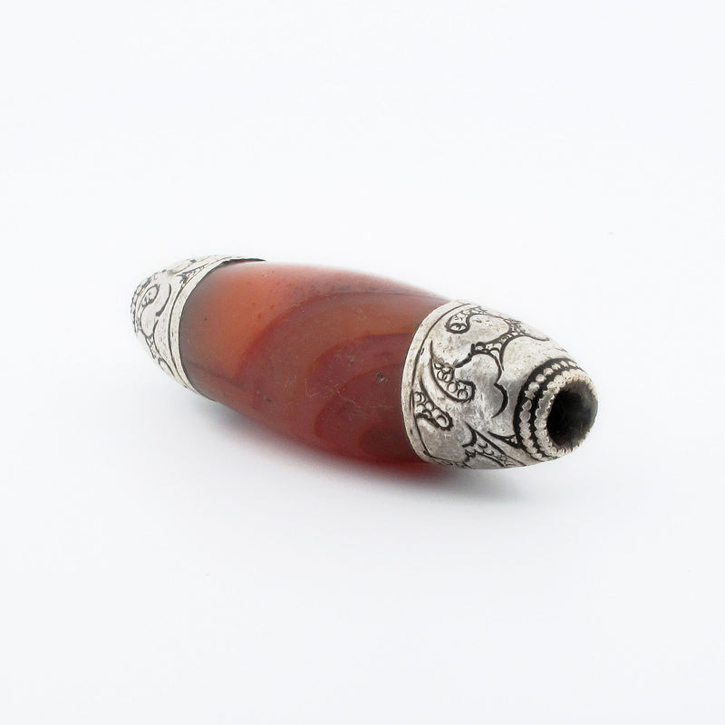 Nepali carved carnelian agate oval bead with repousse sterling silver caps. b4-car400