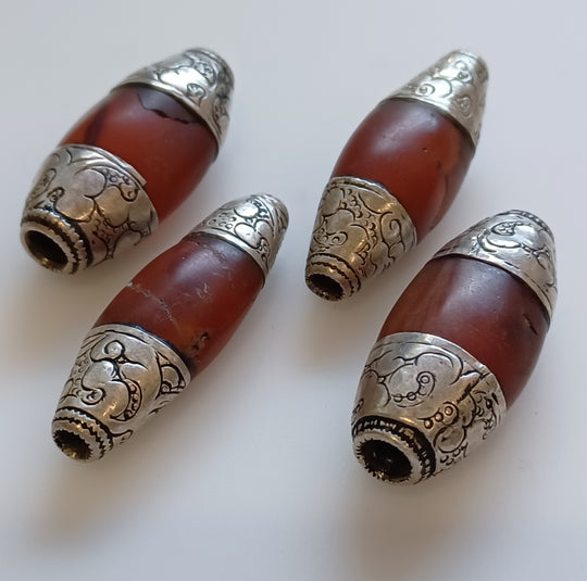4 Tibetan  carved carnelian flattened oval beads with repousse silver caps. 34-36mm. b4-car432