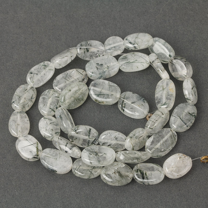 Rutilated Quartz flat oval beads, with black interior crystals. Approximately 12mm.  Strand 16".  b4-qua372