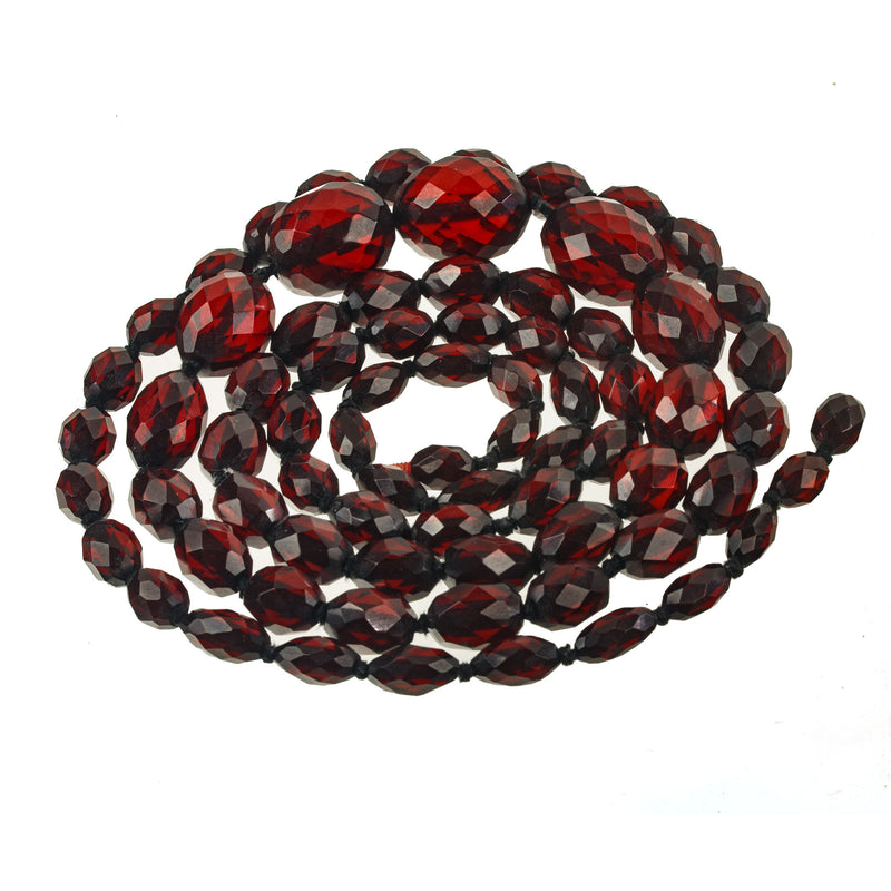 Art Deco knotted and graduated faceted oval cherry amber Bakelite bead strand