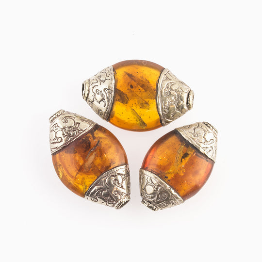 Vintage Tibetan Amber resin oval bead with coin silver bead caps. 46x27x16mm average size. b4-amb105