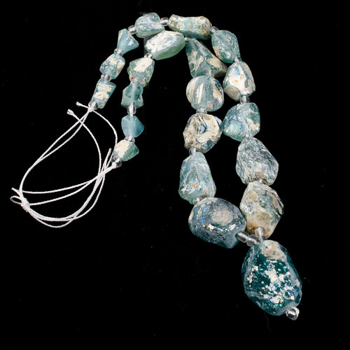 16 inch strand of excavated and reworked ancient glass beads with high rainbow burial patina.