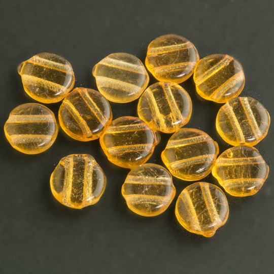 Old Bohemian amber glass two-hole disks. 7mm. Pkg of 25. b11-yo-0824(e)