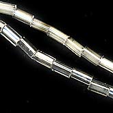 Strand of vintage Japanese mottled silver and satin white glass bugles, 4mm length. Approx. 200 beads per strand. B11-BW-0648