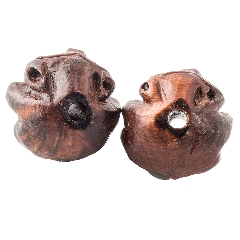 Carved round bead of Ma-Li wood depicting a sitting monkey . 
