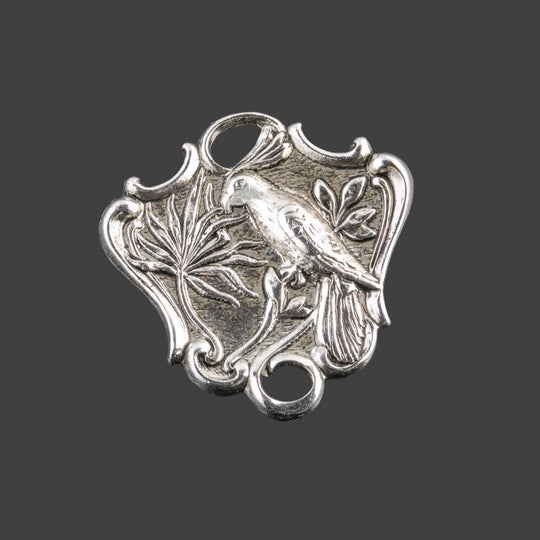 Silver plated brass 2 ring connector depicting a bird on a branch. Pkg. of 2. B9-2301s