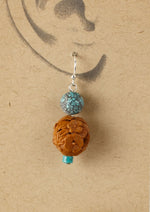 Earrings made of vintage Chinese carved fruit pit and spiderweb turquoise beads.