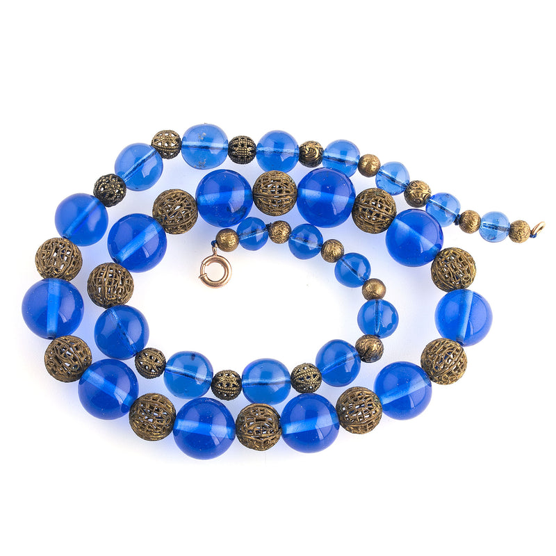 Vintage necklace of luminous blue translucent glass beads and brass filigree beads.  22 1/2 inches. 1920s-30s.  Czechoslovakia