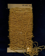 Vintage honey opalescent rocailles, size 9 on braided string per foot. 